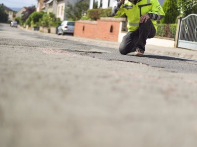 Risse, abgehende Straße mit Rissbreitenschablone 