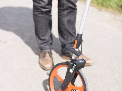 Beweissicherung / Bestandsaufnahme für Straße vor Windenergieanlagen mit Meßrad und Fotoapparat