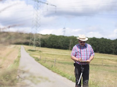Beweissicherung / Bestandsaufnahme für Straße vor Windenergieanlagen mit Meßrad und Fotoapparat